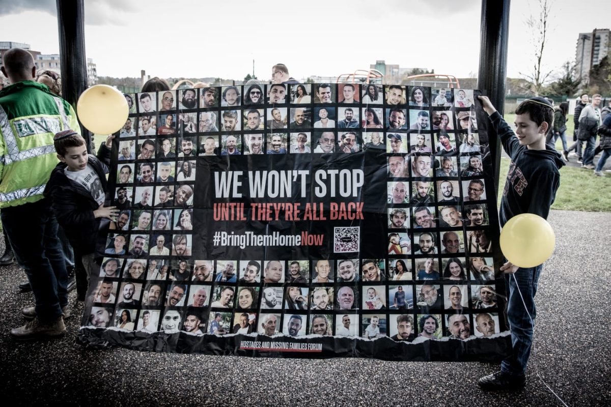 Two boys hold a banner calling for the release of the hostages