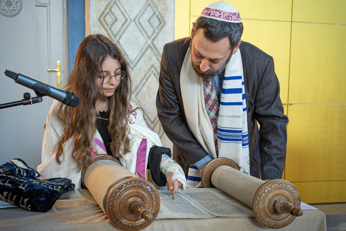 Hannah reads from the Torah alongside her dad Rabbi Misha Kapustin